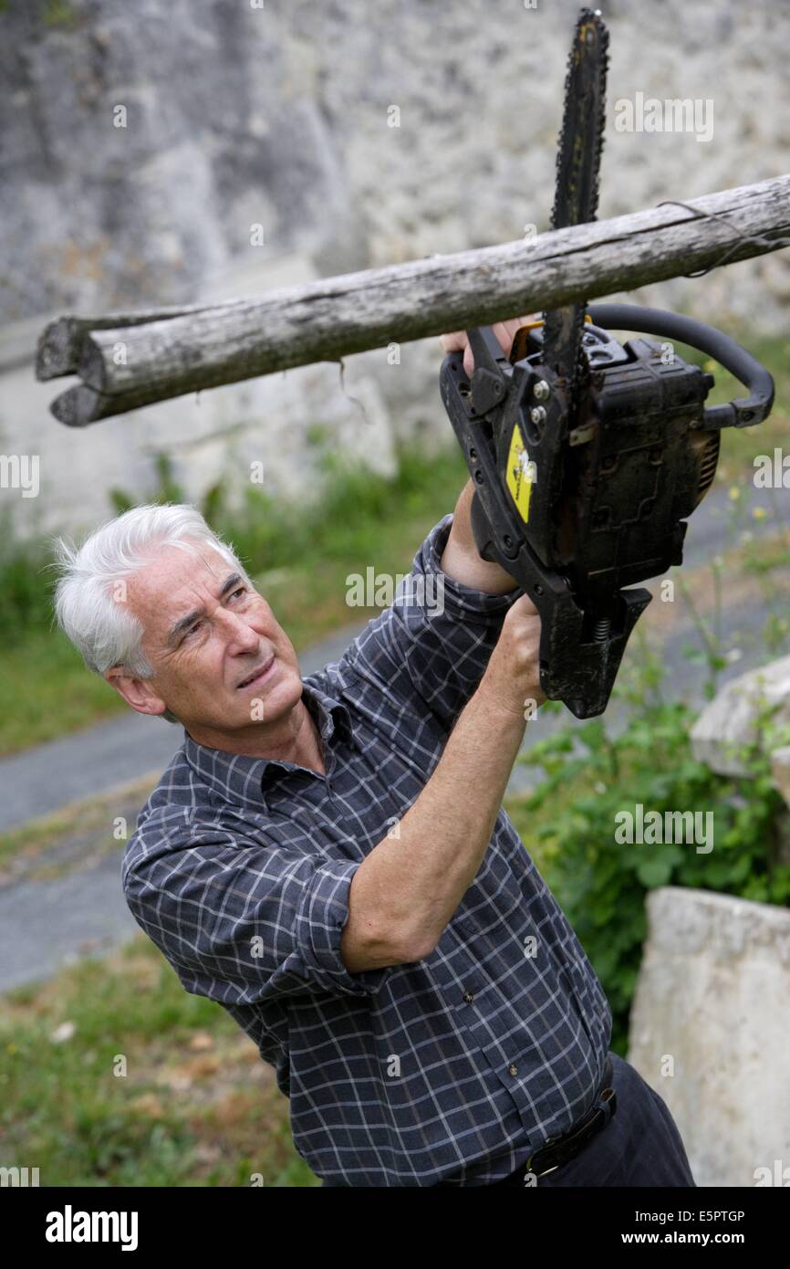 Man en utilisant une scie à chaîne. Banque D'Images