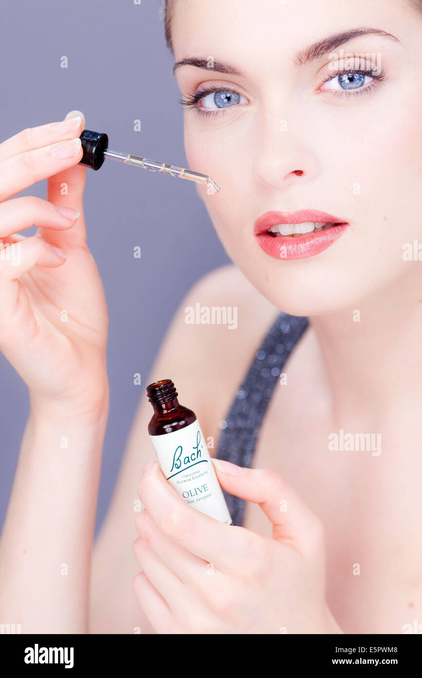 Femme à l'aide d'un remède de Bach (extrait de fleur de liquide). Banque D'Images