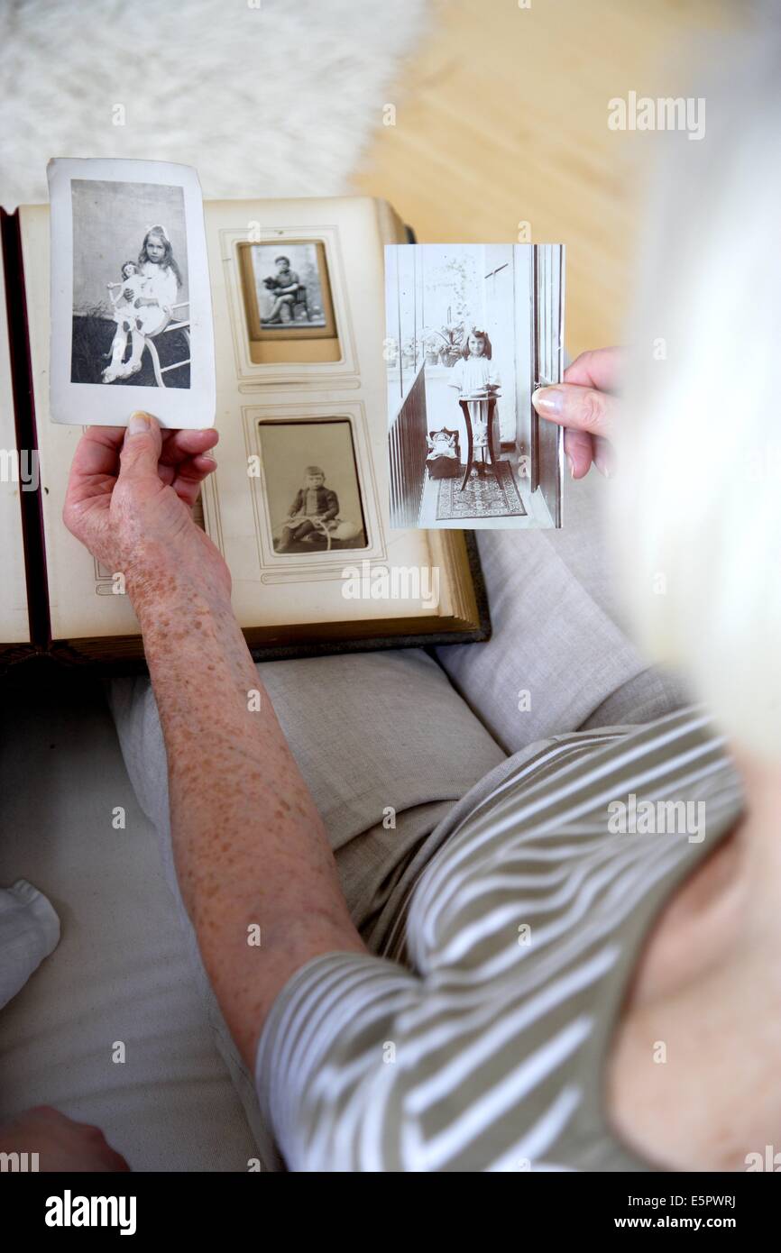 Femme âgée à la recherche de photos anciennes. Banque D'Images