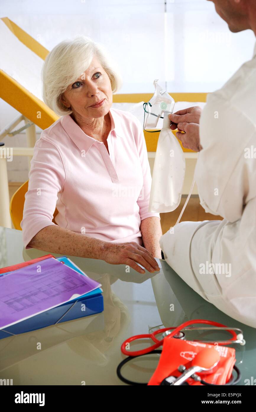 Doctor showing patient âgé masque à oxygène pour oxygenotherapy. Banque D'Images