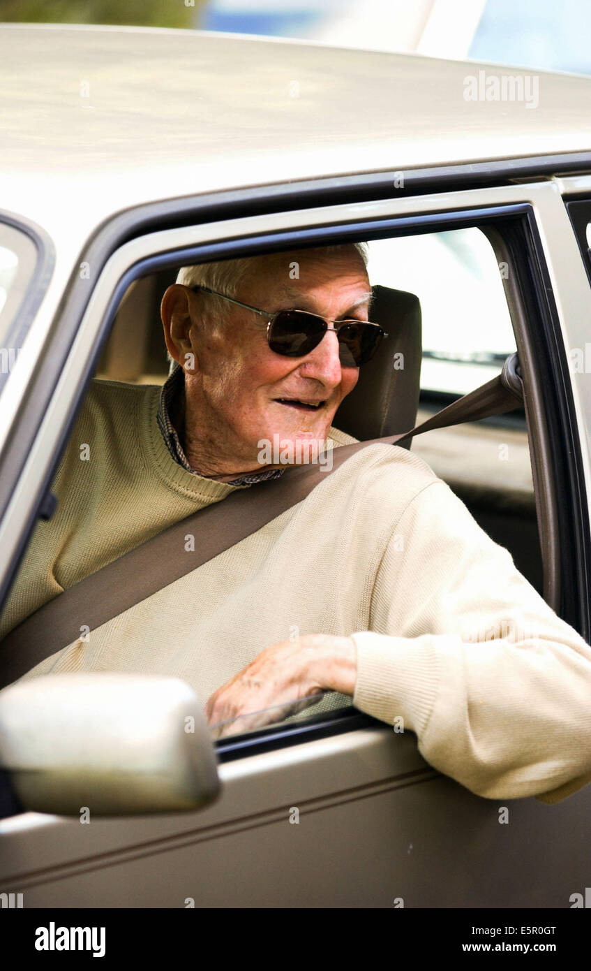 Un homme âgé à la conduite d'une voiture. Banque D'Images