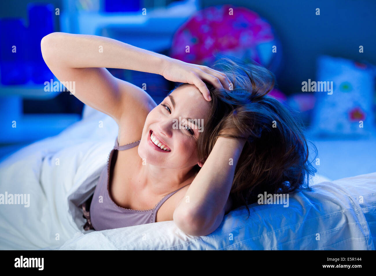 Femme de se réveiller et s'étendant dans le lit. Banque D'Images