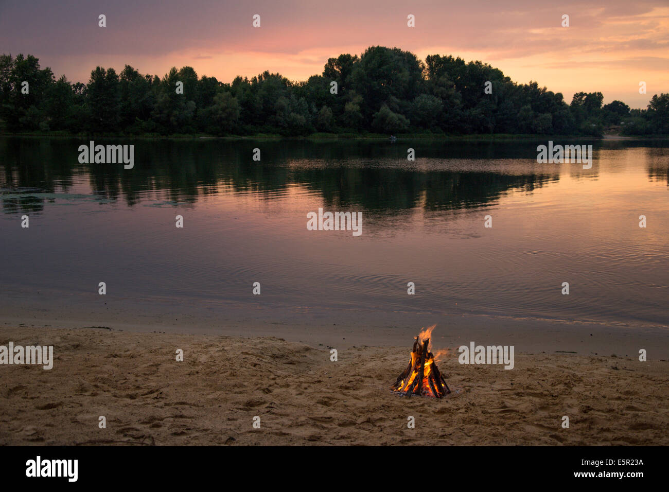 Joie sur la rive de la rivière au coucher du soleil Banque D'Images