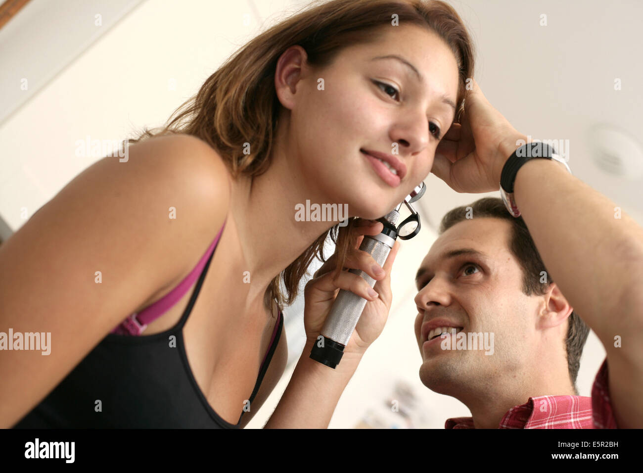 Médecin examinant les oreilles d'un patient avec un otoscope. Banque D'Images