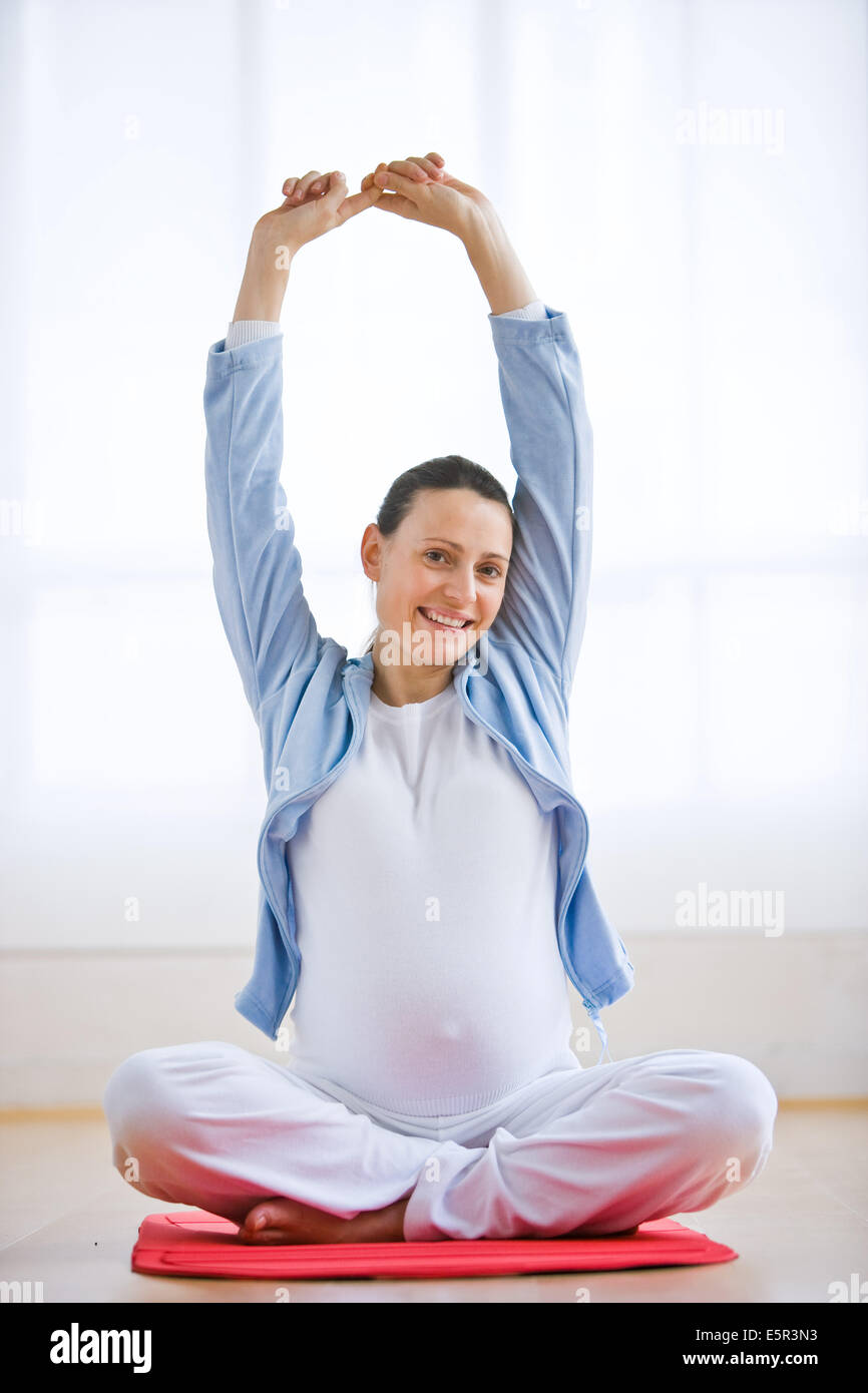 Femme enceinte s'étendant les bras. Banque D'Images