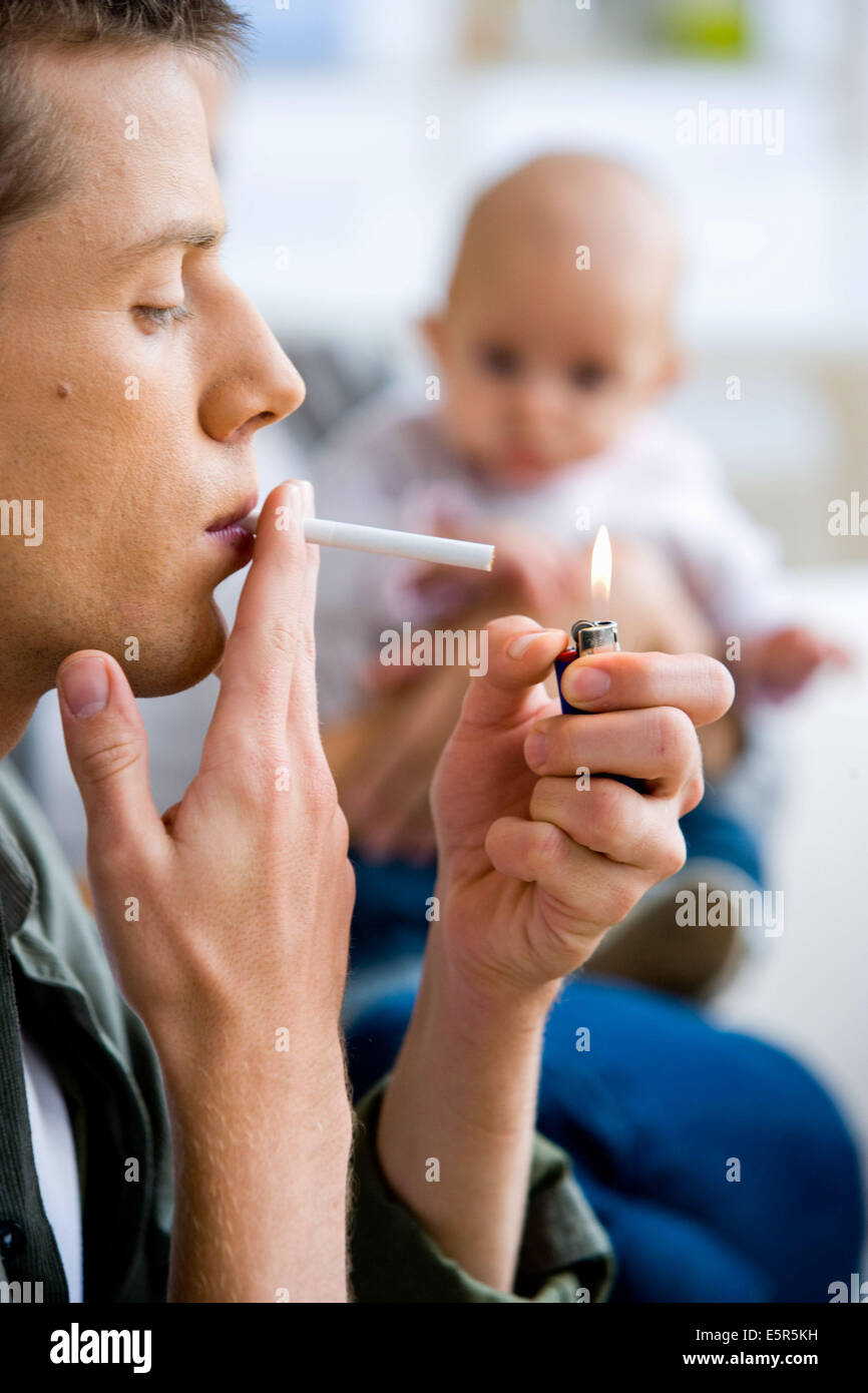 Man smoking a cigarette près d'un bébé Photo Stock - Alamy