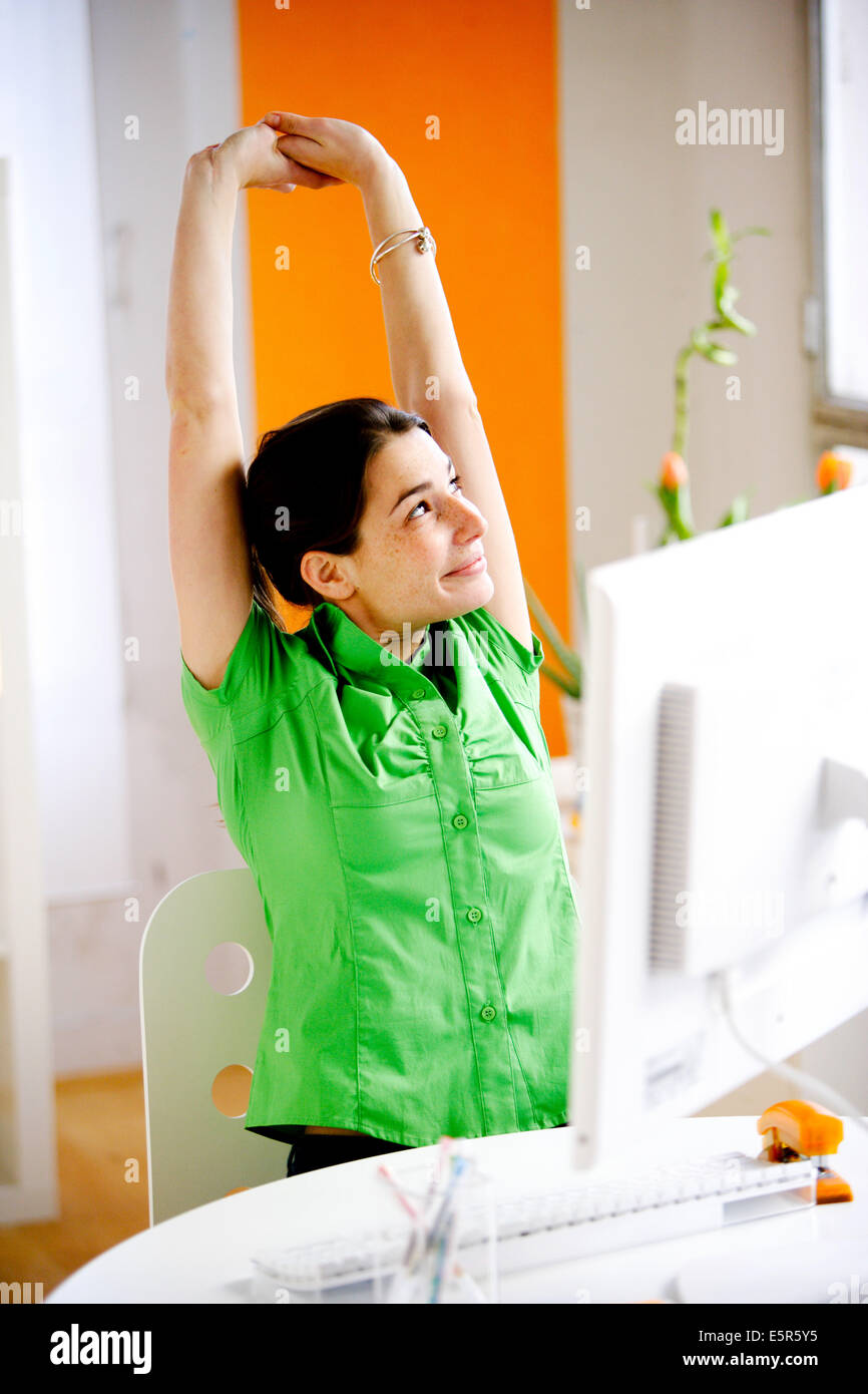 Office woman stretching arms au travail. Banque D'Images