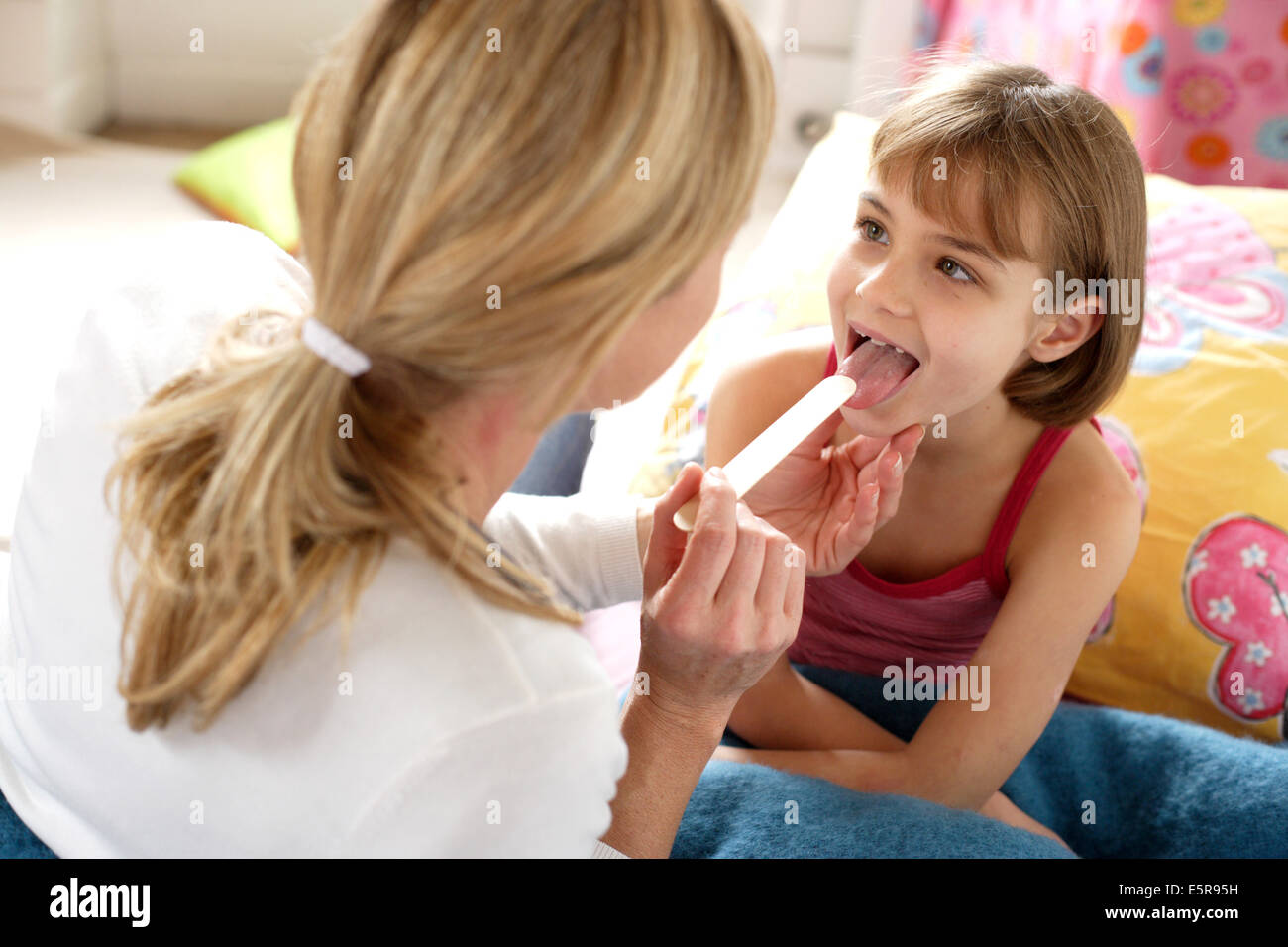 Médecin examinant la gorge d'une fillette de 7 ans. Banque D'Images