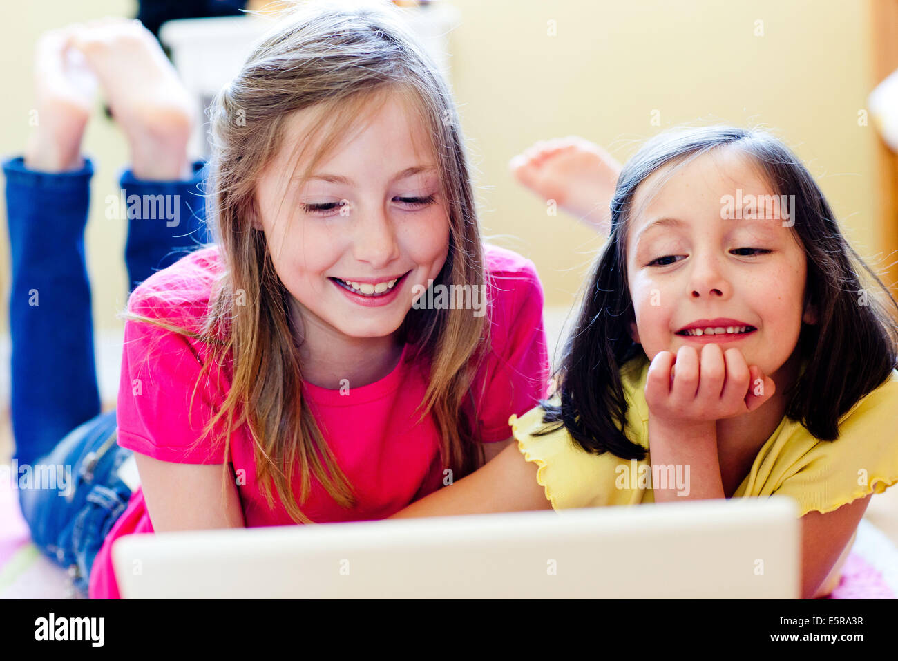 7 et 11-year-old sisters en utilisant un ordinateur portable. Banque D'Images