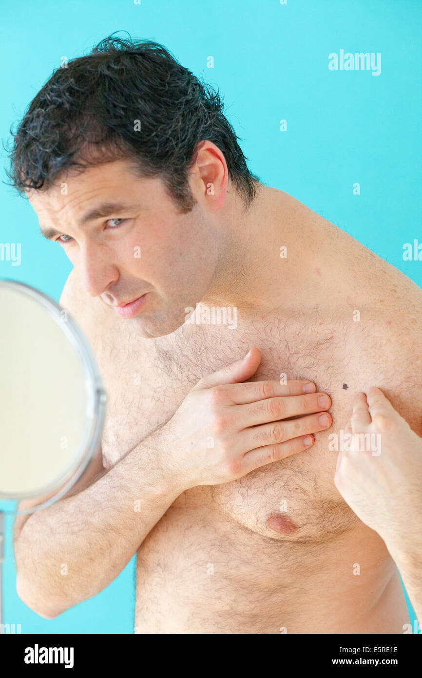 Woman inspecting beauty spot en miroir. Banque D'Images