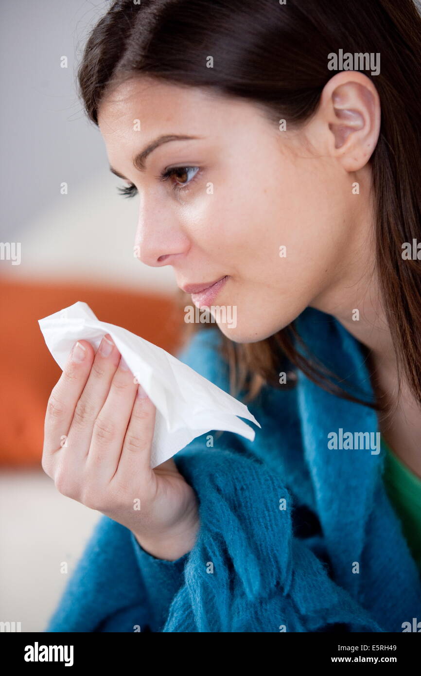 Femme souffrant de rhinite allergique s'être mouché le nez avec un mouchoir. Banque D'Images