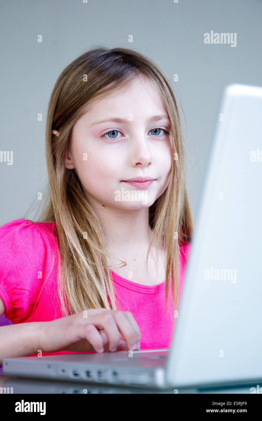 9 ans, fille, à l'aide d'un ordinateur portable. Banque D'Images