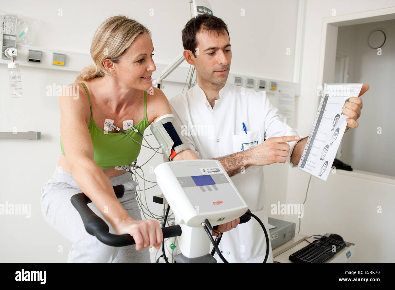 Femme de faire des exercices de réadaptation cardiaques sur ergometric location, Limoges, France l'hôpital. Banque D'Images
