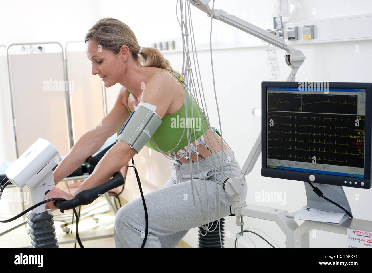 Femme de faire des exercices de réadaptation cardiaques sur ergometric location, Limoges, France l'hôpital. Banque D'Images