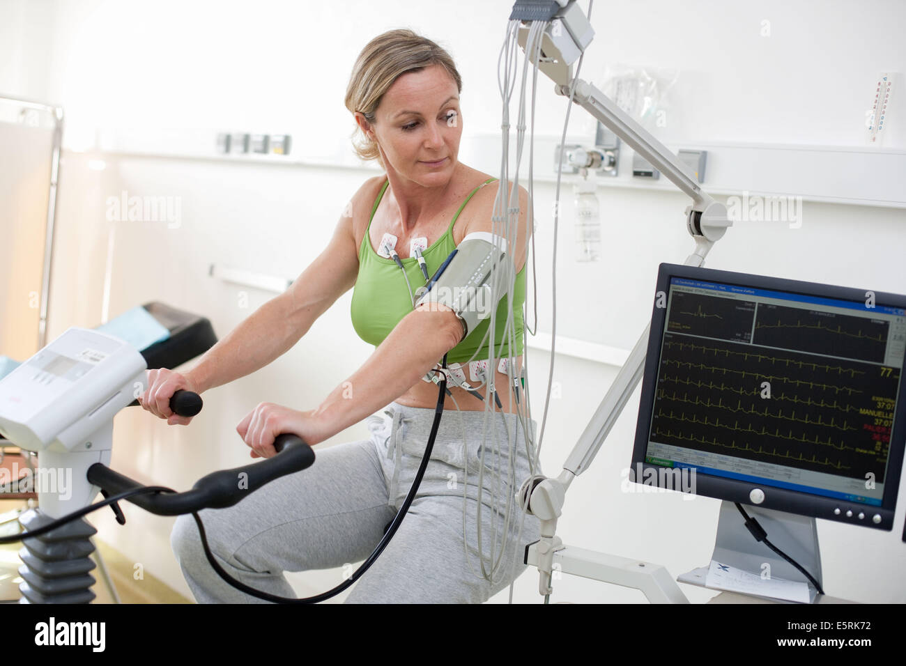 Femme de faire des exercices de réadaptation cardiaques sur ergometric location, Limoges, France l'hôpital. Banque D'Images