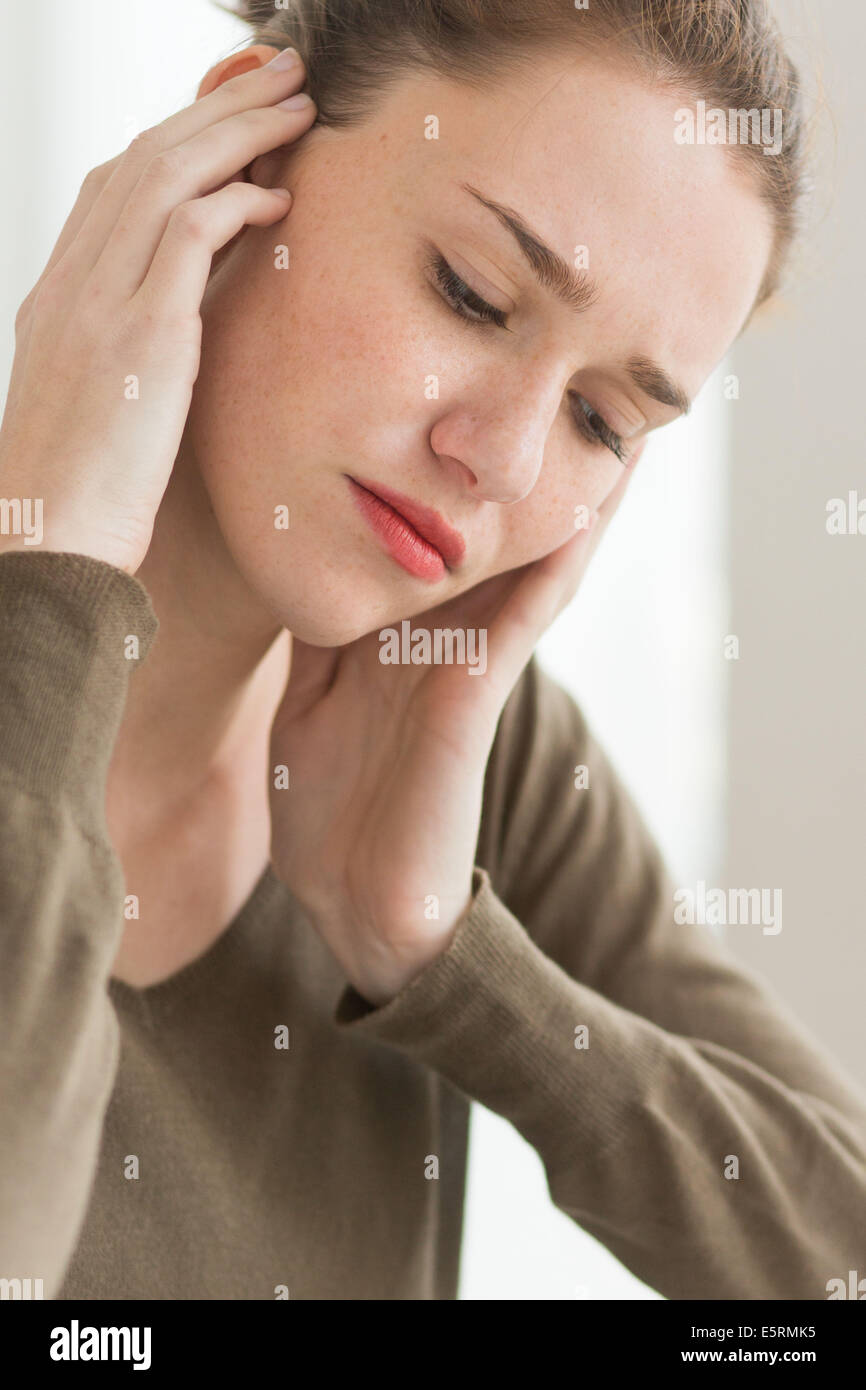 Femme détient la main à son oreille douloureuse. Banque D'Images