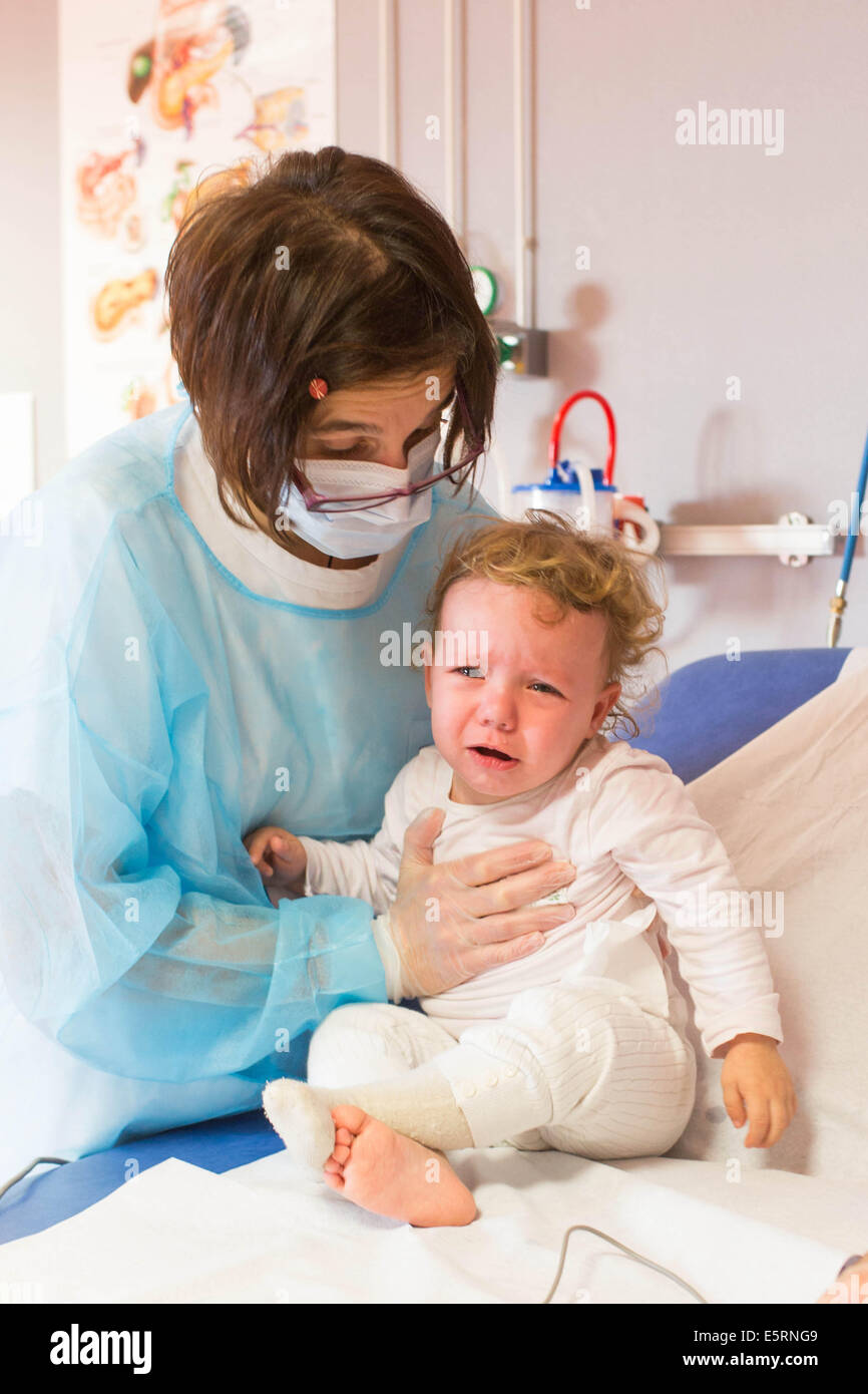 Examen annuel d'une petite fille de 18 mois souffrant de mucoviscidose. Ici kinésithérapie respiratoire session. Limoges Banque D'Images