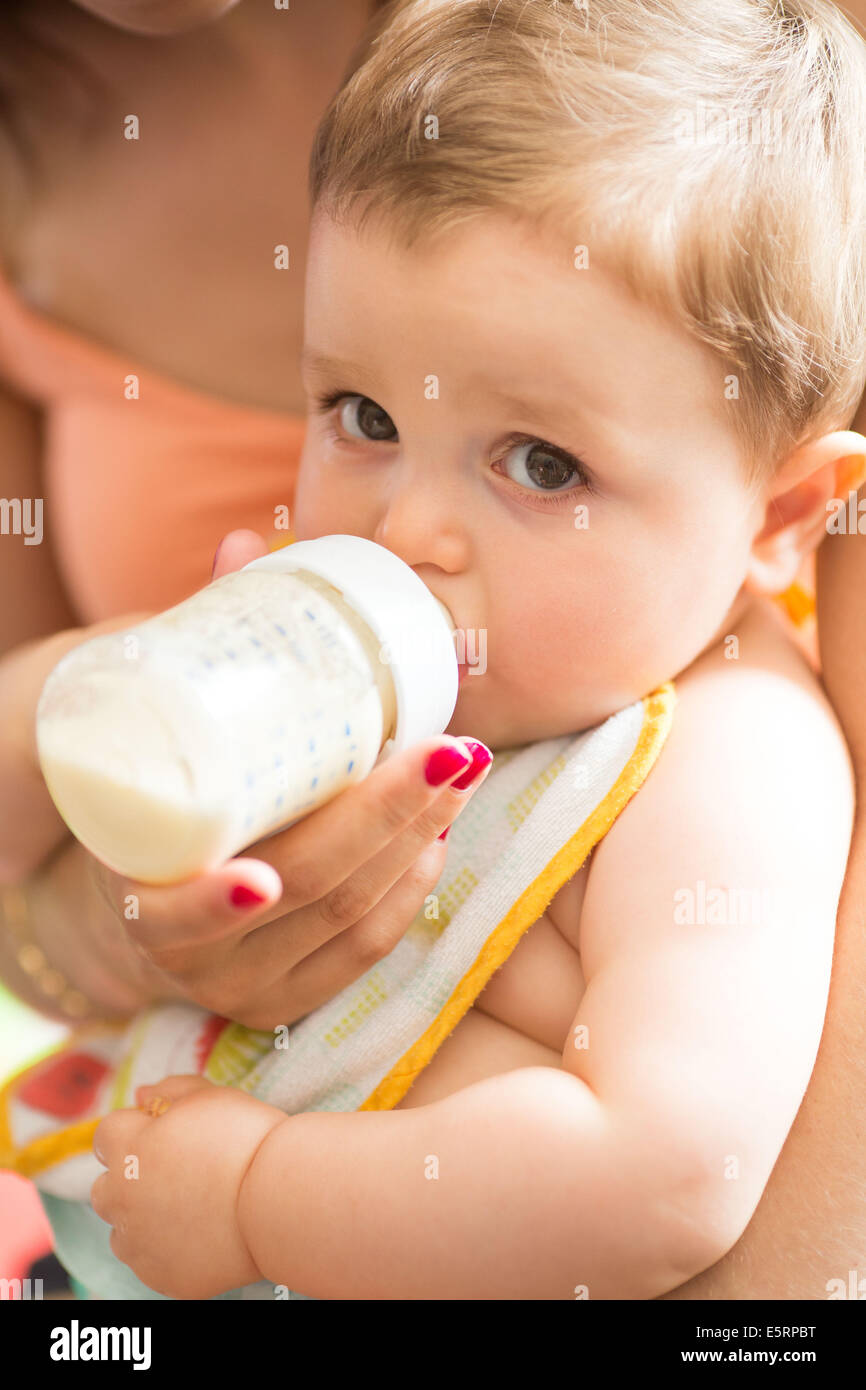 12 mois bébé garçon boire du lait à partir d'une bouteille. Banque D'Images