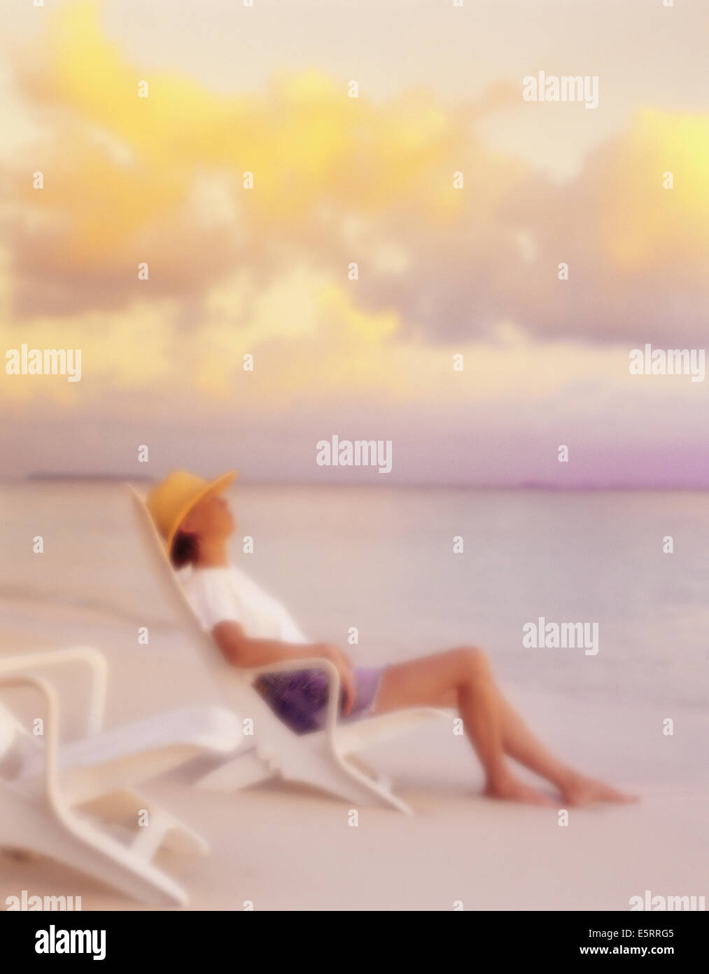 Woman relaxing on beach chair de la rive sur l'île de Bandos, North Male Atoll, Maldives Banque D'Images