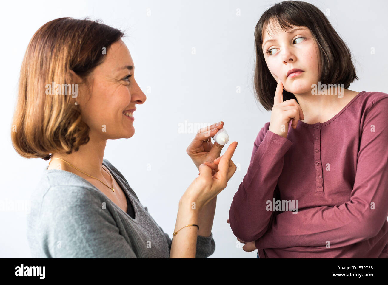 Mère l'application de pommade sur le visage de sa fille Photo Stock - Alamy