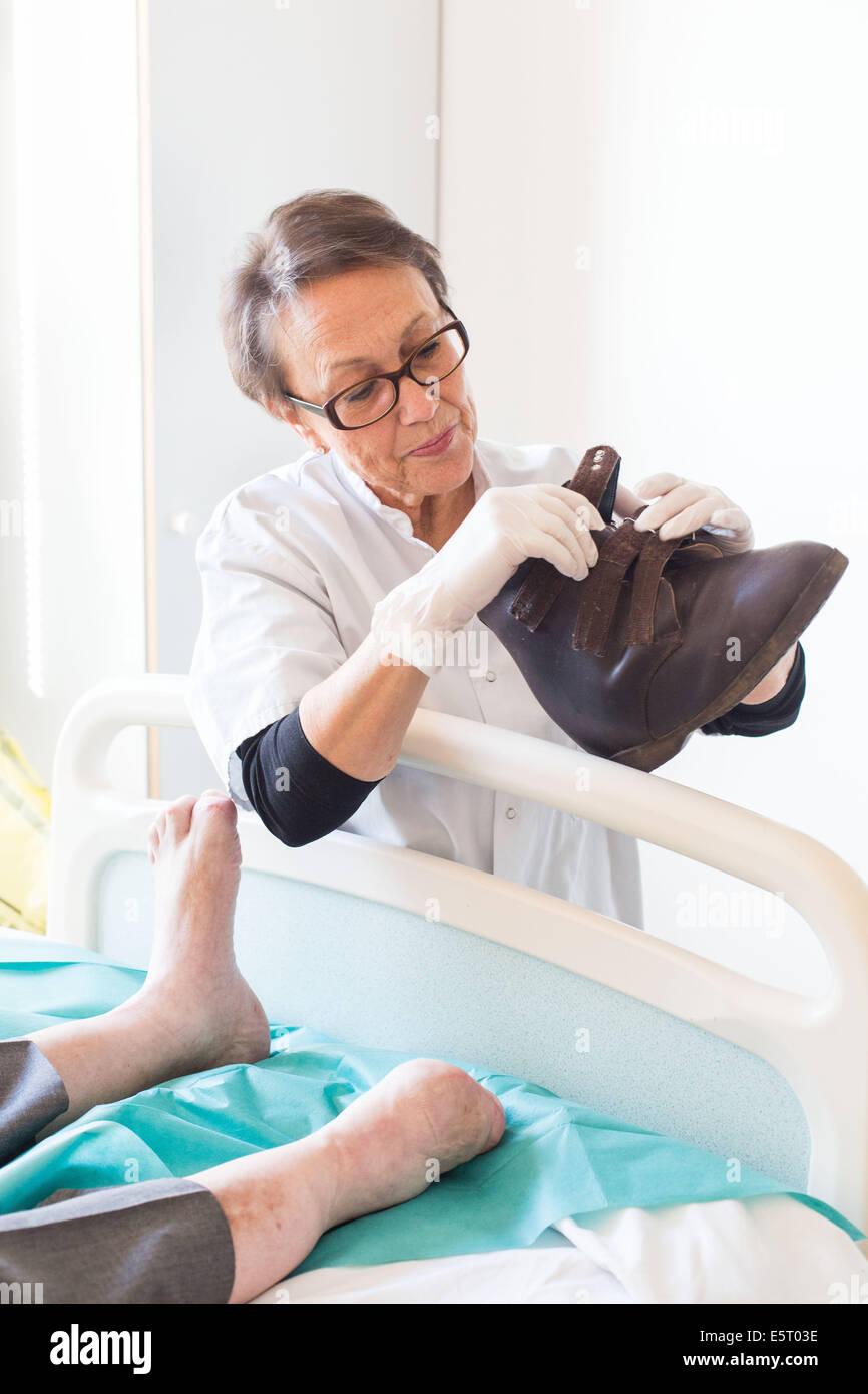 Podiatre examinant la chaussure orthopédique d'un patient diabétique,  l'hôpital d'Angoulême, France Photo Stock - Alamy