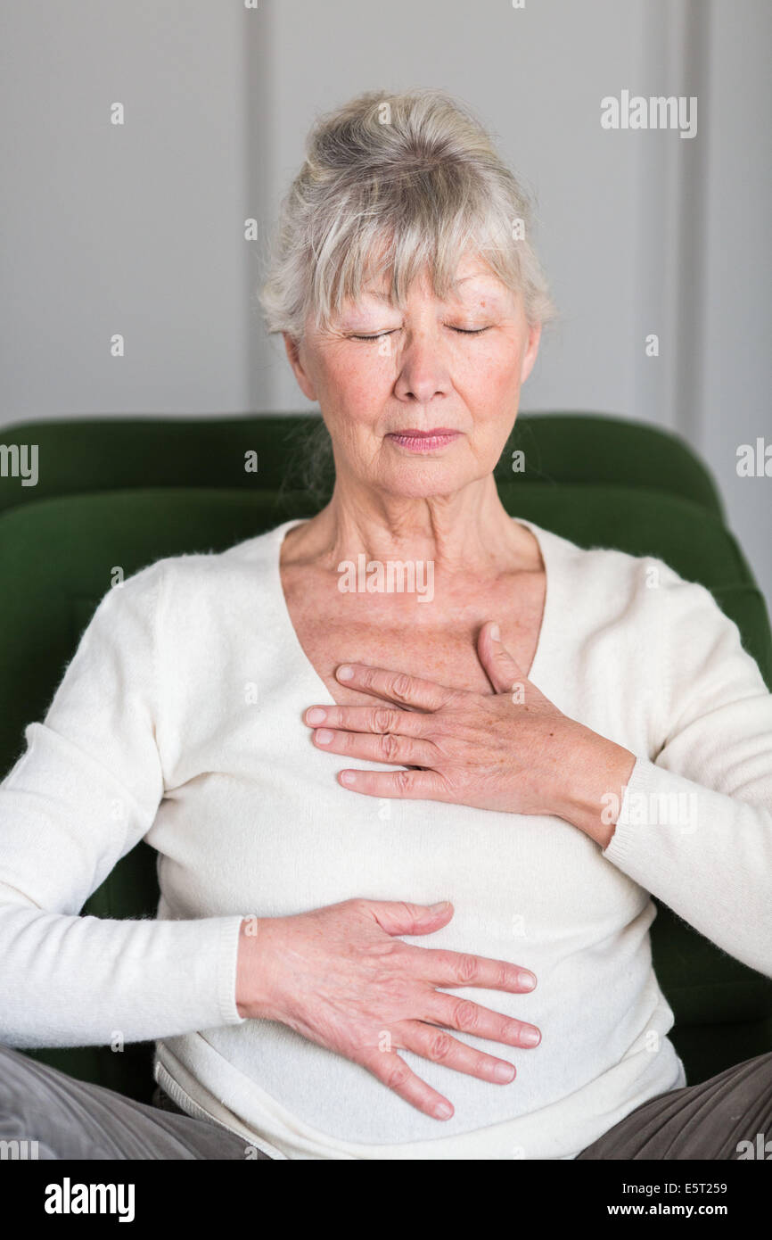 Senior woman pratiquer des exercices respiratoires. Banque D'Images