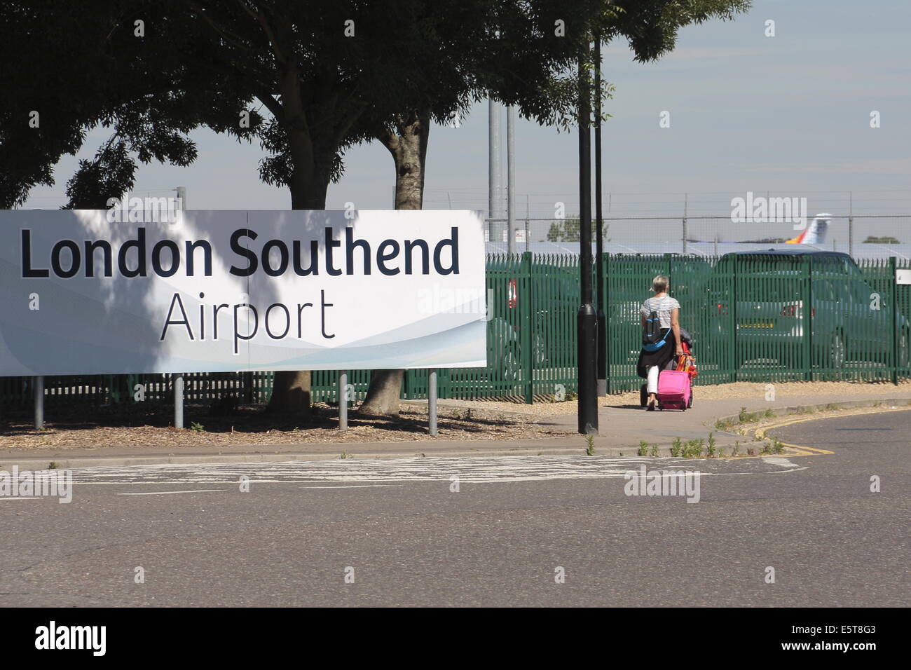 Une femme wheeling une valise, entrant dans l'aéroport de Londres Southend. Banque D'Images