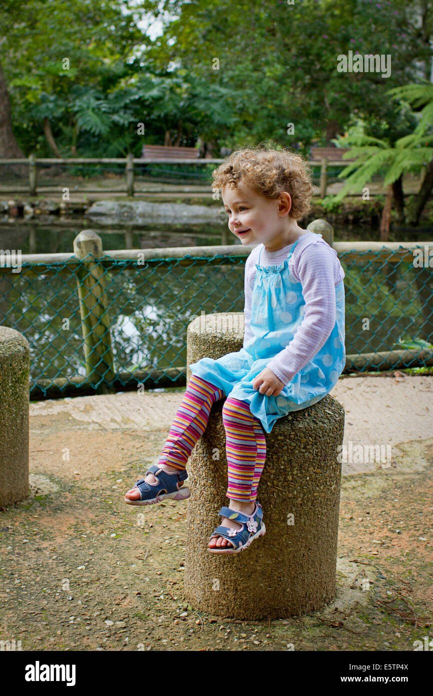 Jeune fille assise dans le parc, jardins Arderne Banque D'Images