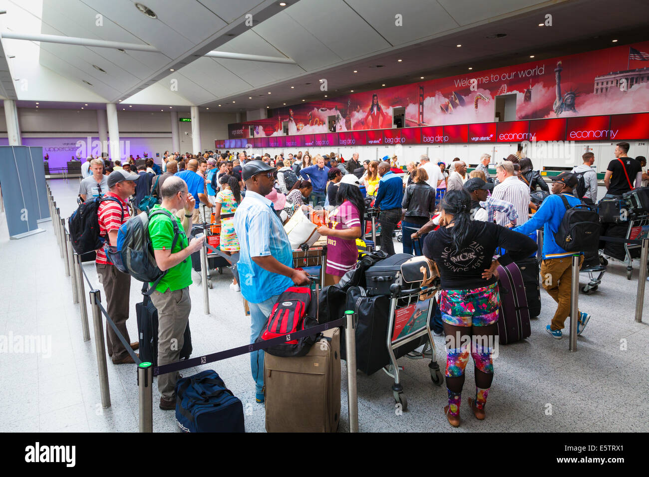 Longue file d'attente des passagers en attente d'enregistrement dans un bureau à Virgin Atlantic. Banque D'Images
