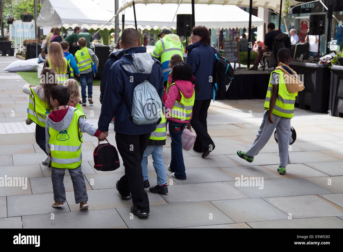 La garde des enfants à Dig The City Deansgate, un festival annuel de jardinage urbain organisé par le Business Improvement District de Manchester – BID.Des expositions florales, des arrêts de bus et un jardin Vimto transformant le centre-ville de Manchester à l'entrée de Dig the City.Seize jardins exposés pendant le festival de jardinage urbain, du 2 au 10 août.Chacun a été conçu spécialement pour l'événement, avec leurs concepteurs devant relever les défis du jardinage dans un petit espace urbain. Banque D'Images