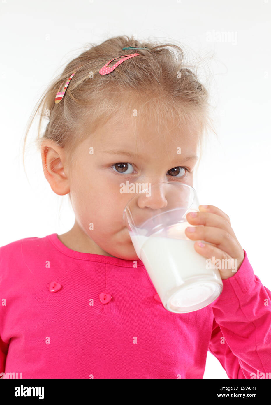 Petite fille de boire dans un verre de lait Banque D'Images