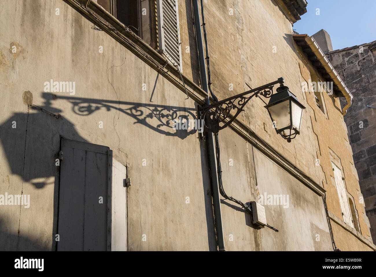 Lampe en fer forgé et son ombre sur un mur à la place de la République, Arles, France. JMH6264 Banque D'Images