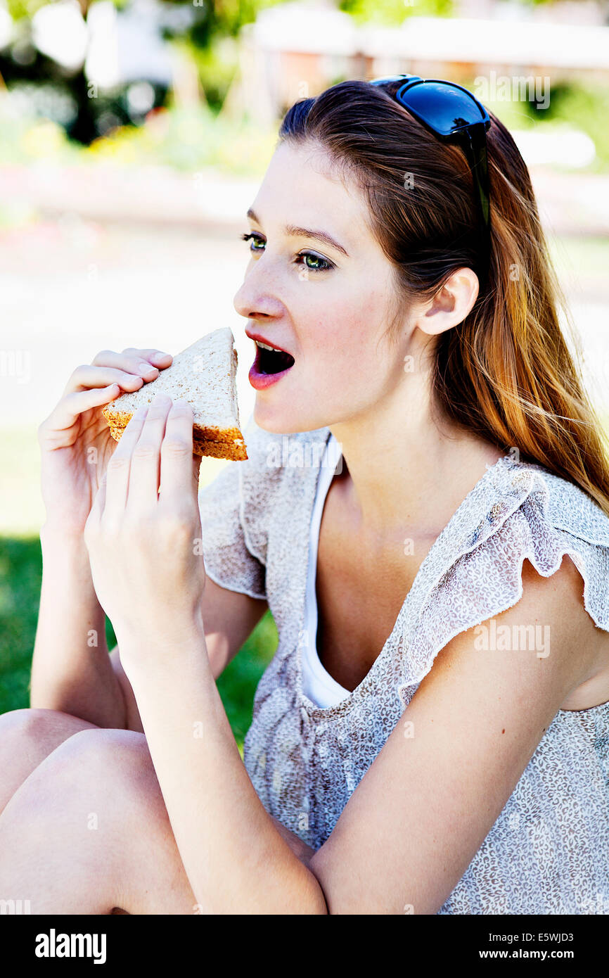 Femme en train de manger un sandwich Banque D'Images