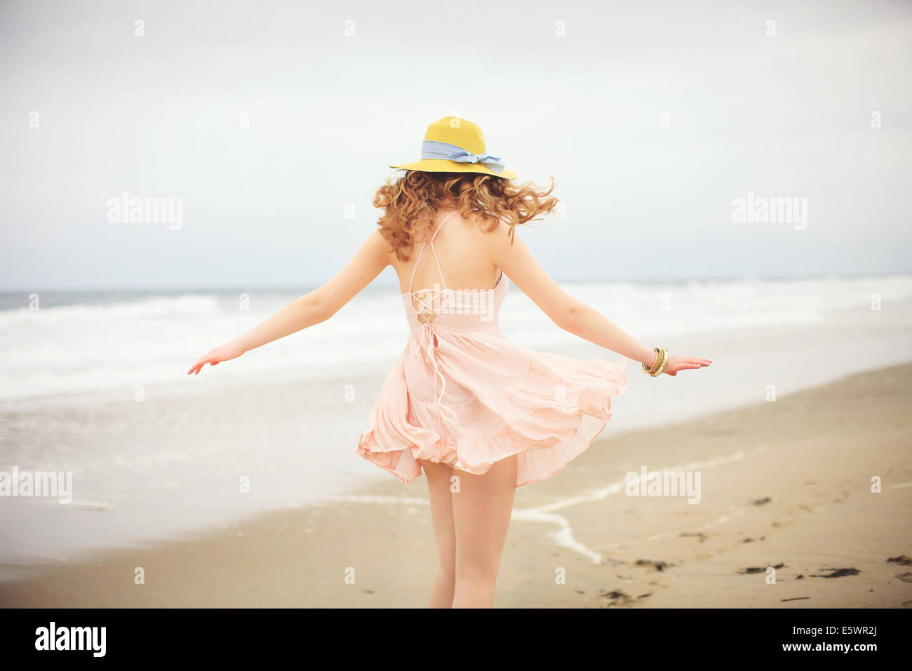 Vue arrière de l'adolescente se promener sur la plage, l'établissement Hampton, New Hampshire, USA Banque D'Images