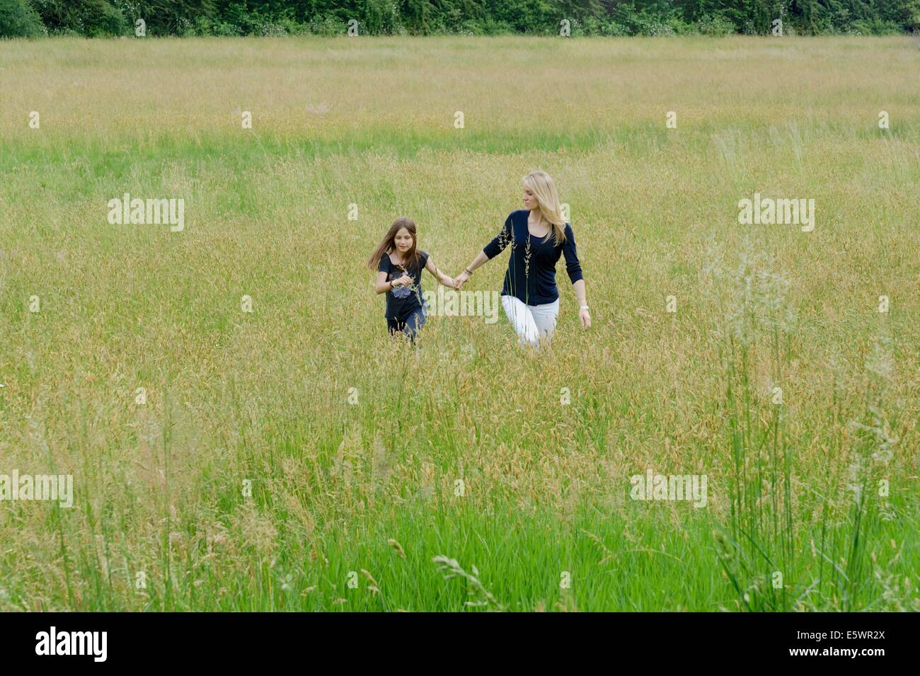 Mère et fille se baladant dans la longue herbe domaine Banque D'Images