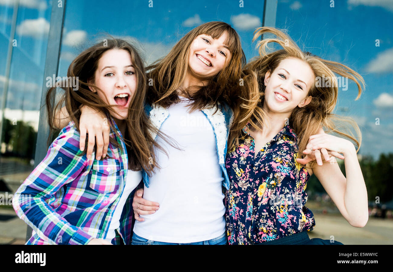 Trois jeunes femmes secouant les cheveux dans une rangée Banque D'Images