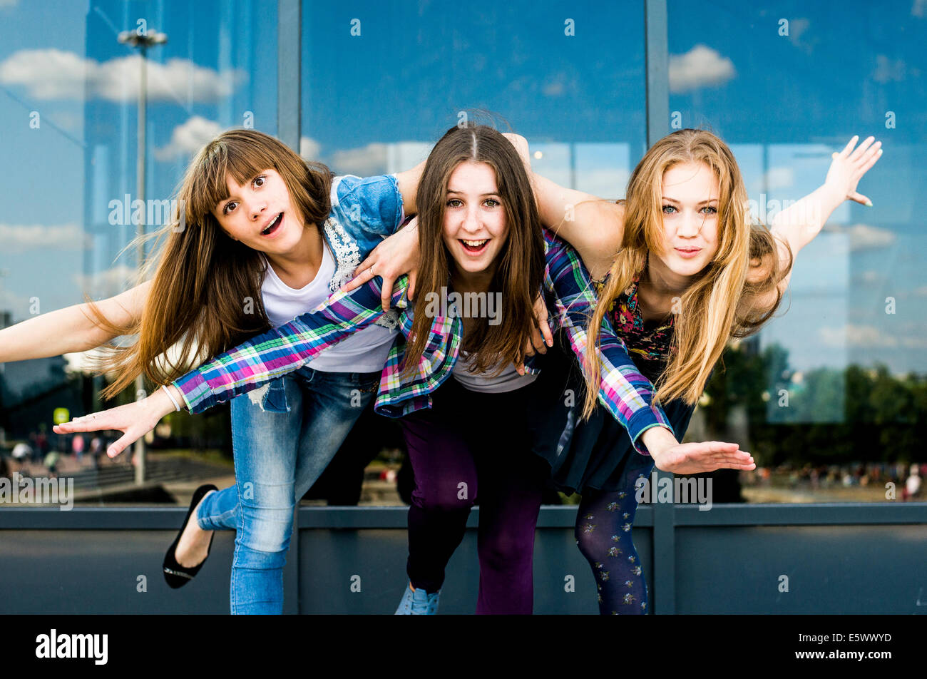 Trois jeunes femmes sur une jambe tout en se penchant vers l'avant Banque D'Images