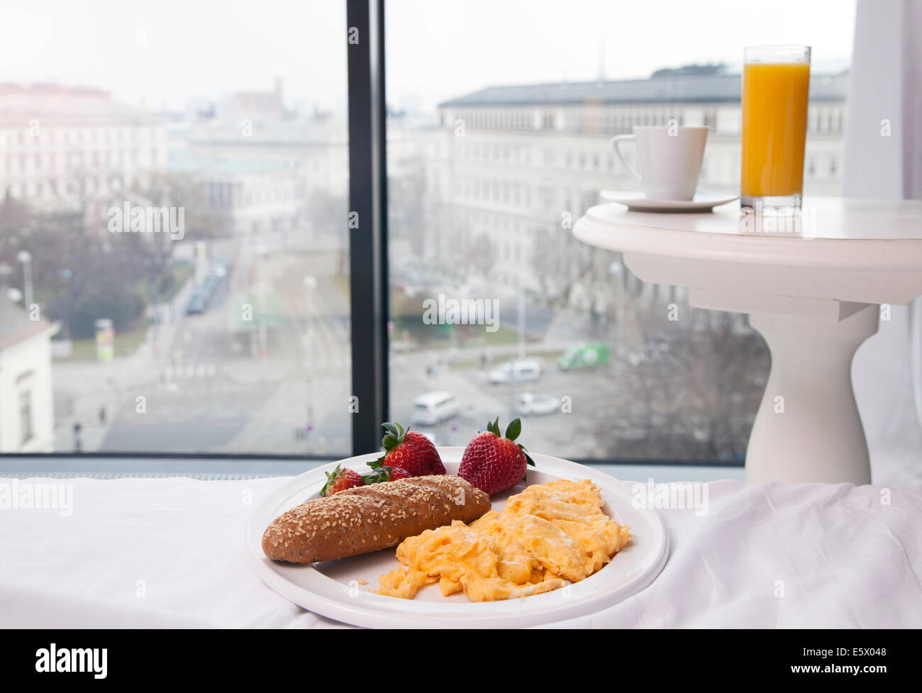 Petit-déjeuner d'œufs brouillés, jus et café par la fenêtre de l'hôtel avec vue, Vienne, Autriche Banque D'Images
