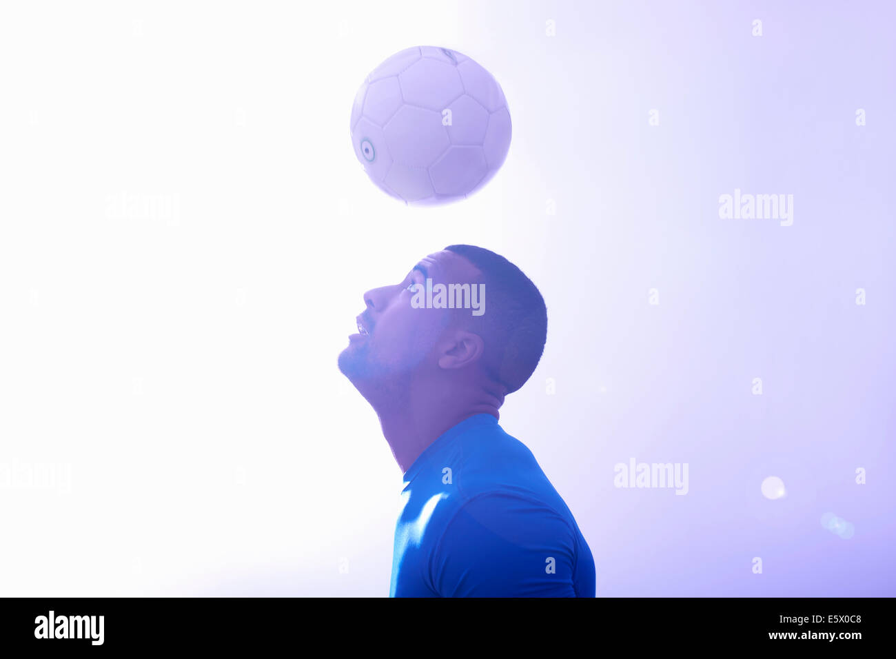 Portrait de jeune homme joueur de foot ball de maintien de l'air avec l'unité de coupe Banque D'Images
