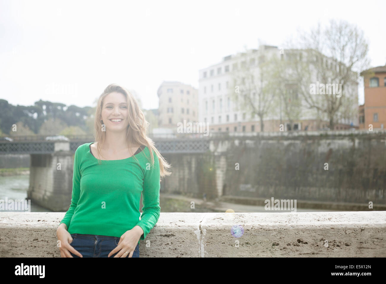 Young woman leaning against wall, Isola Tiberina, Rome, Italie Banque D'Images