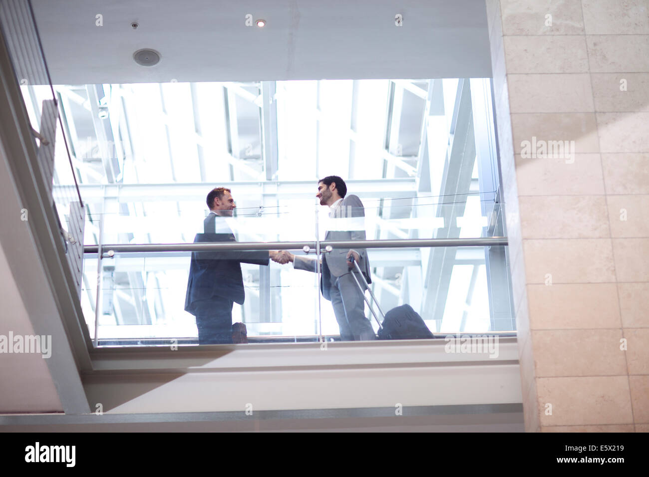 Deux jeunes businessmen shaking hands on conference centre balcon Banque D'Images
