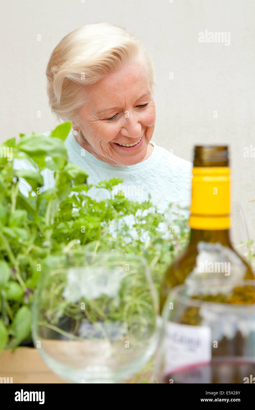 Senior woman sitting at table de jardin Banque D'Images