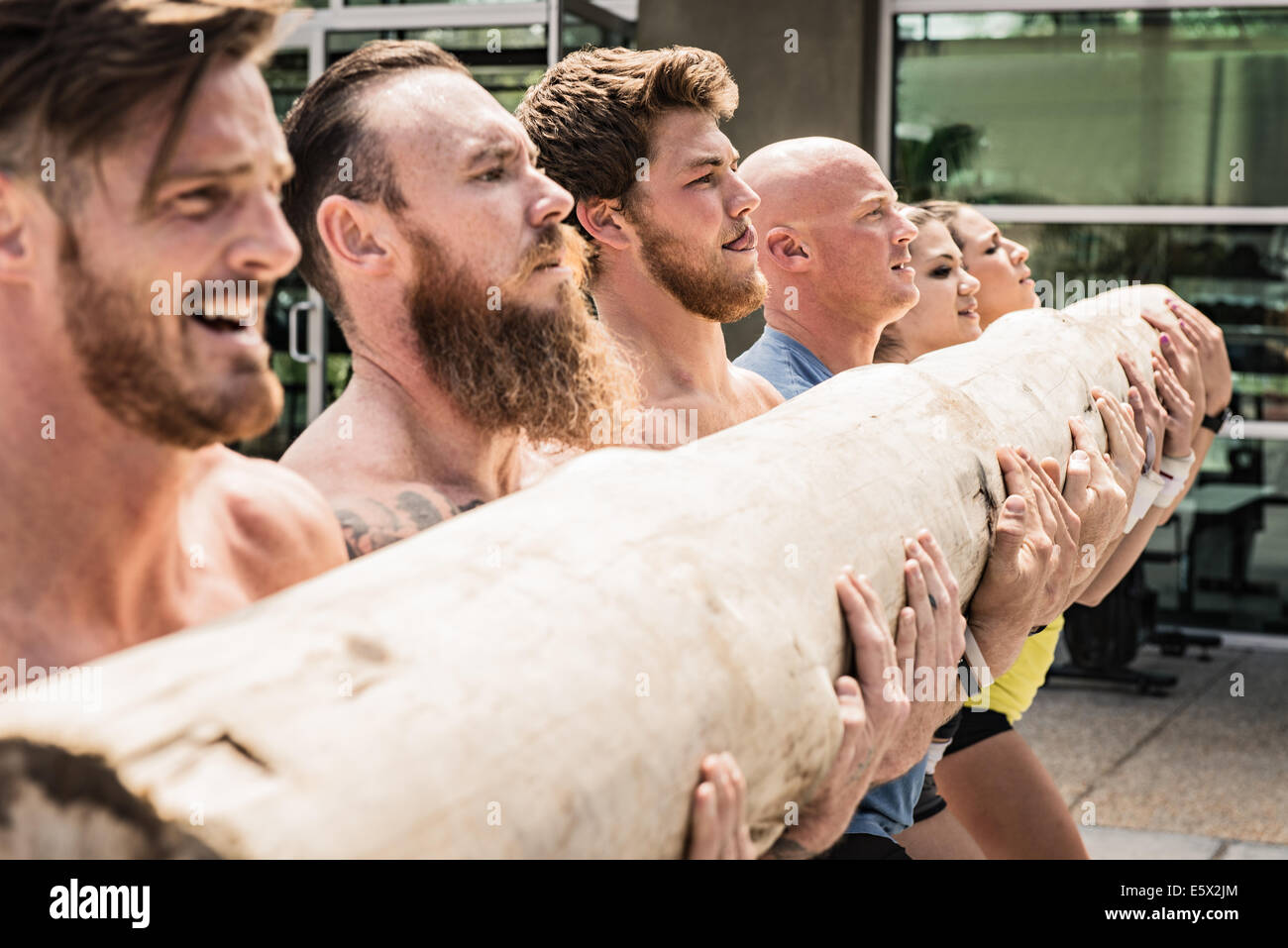 Équipe d'hommes et de femmes journal de levage Banque D'Images