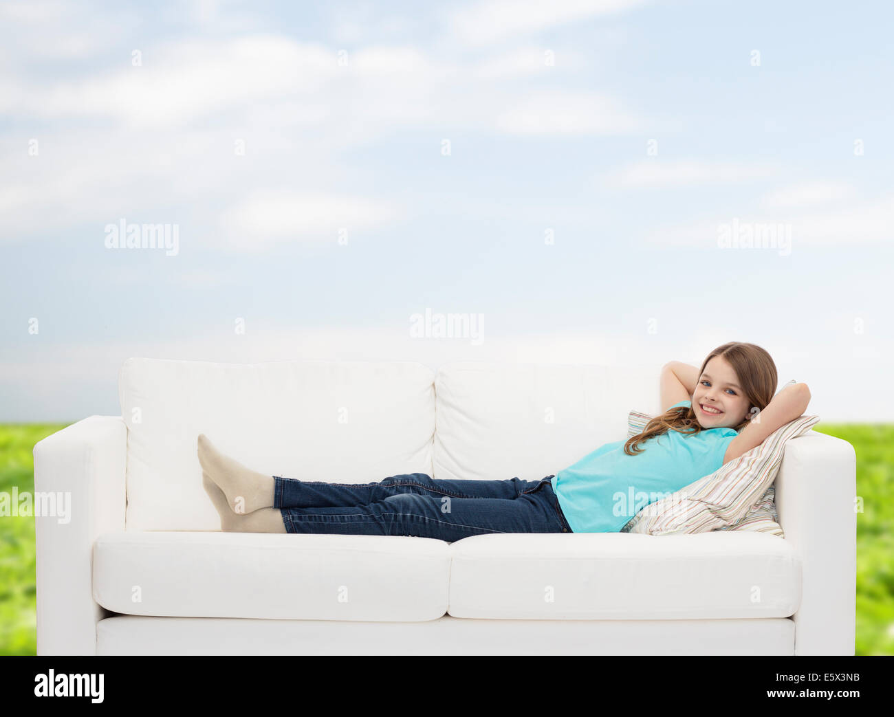 Smiling little girl lying on sofa Banque D'Images