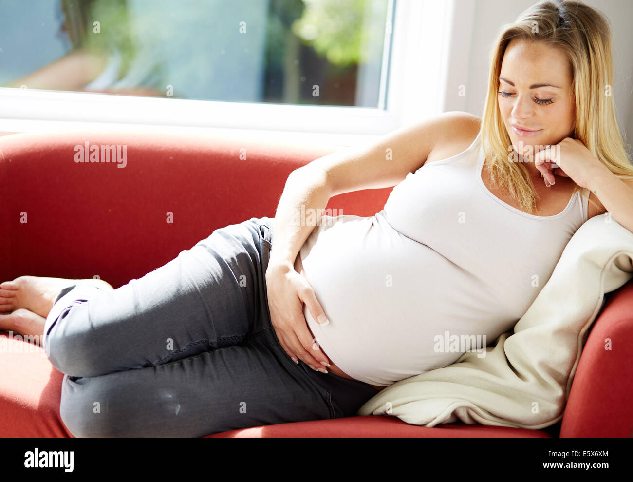 Femme enceinte sat relaxing on sofa Banque D'Images