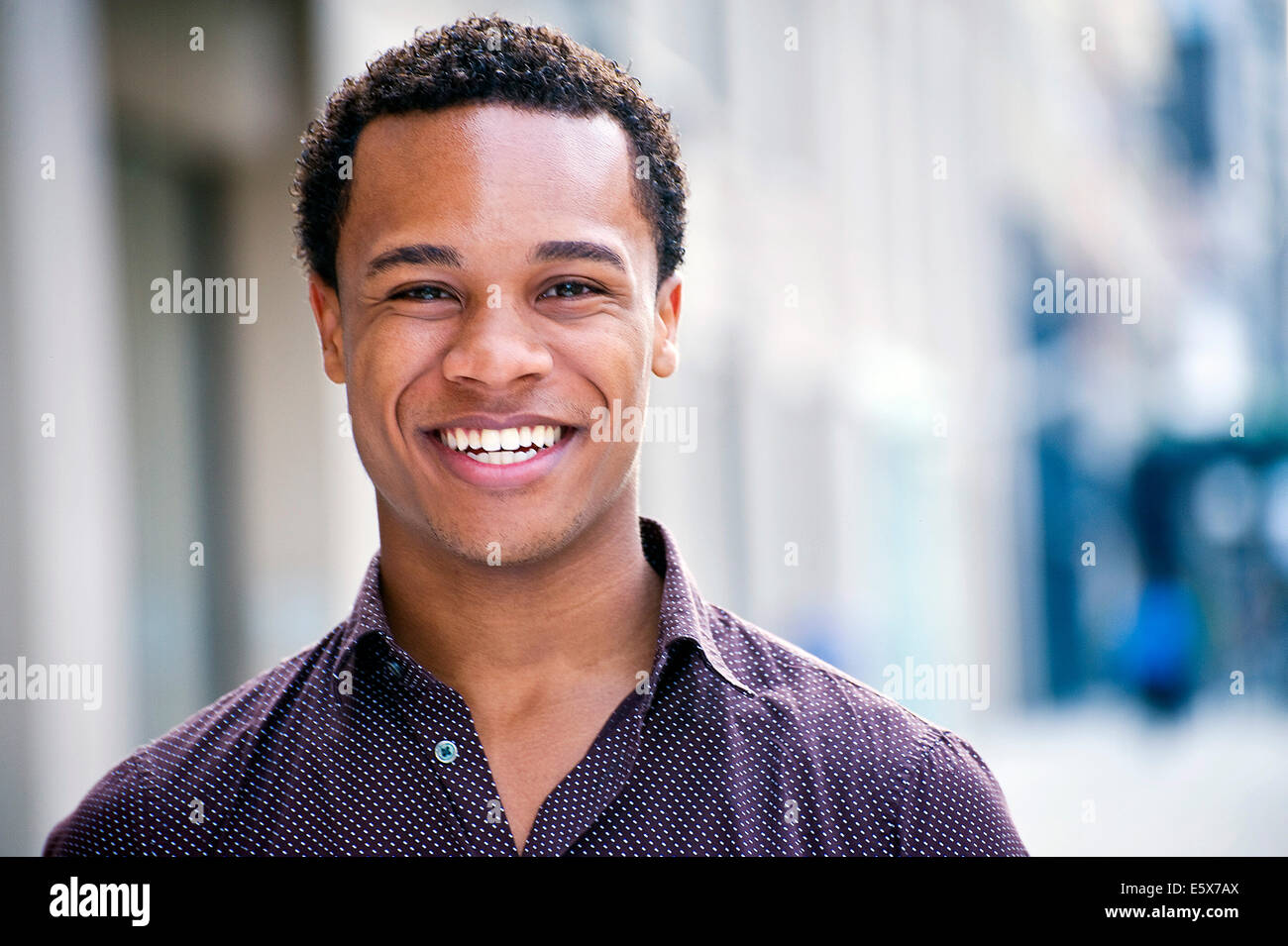 Portrait de jeune homme chatting on city street Banque D'Images