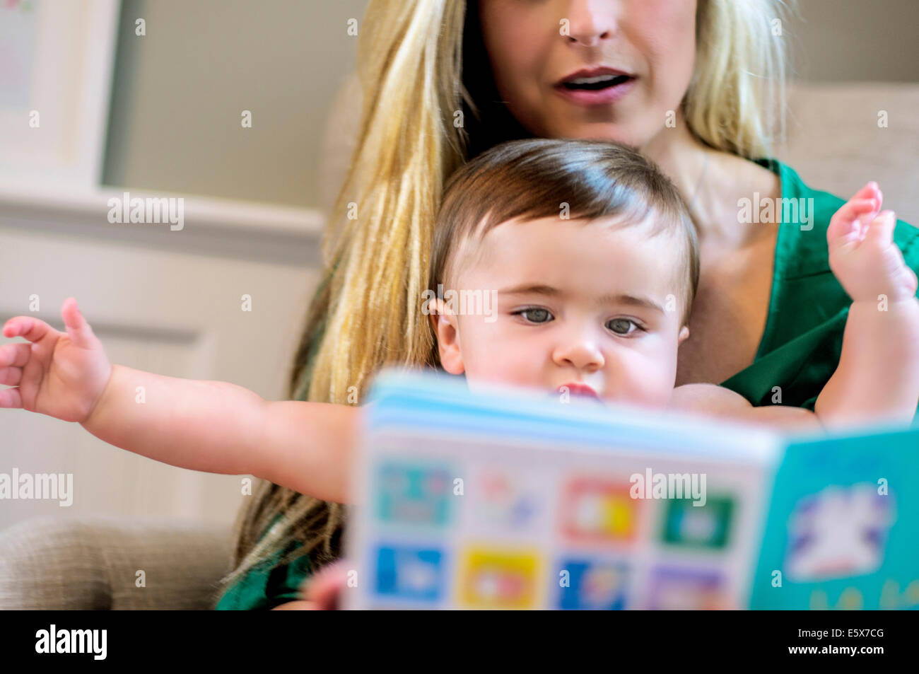 Mid adult mother reading picture book pour bébé fille Banque D'Images