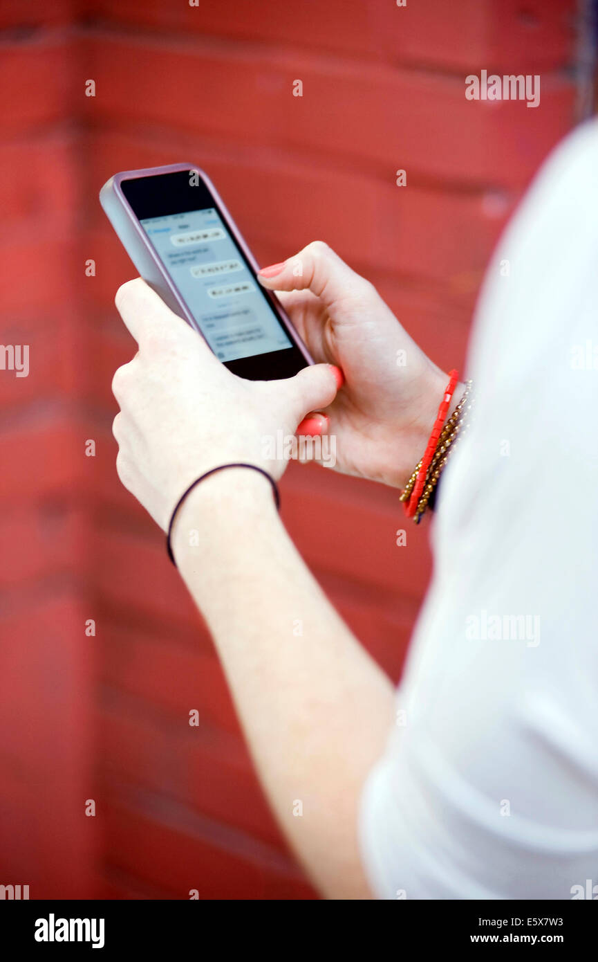Close up of young woman's hands texting on smartphone Banque D'Images