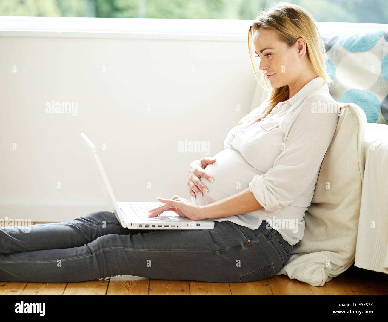 Pregnant woman using laptop computer Banque D'Images