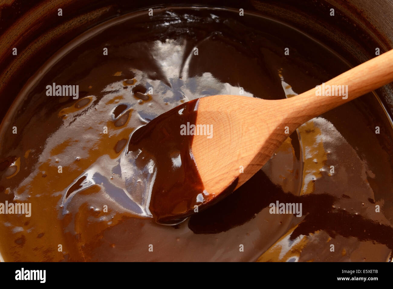 Le chocolat noir fondu dans une casserole, d'être remué avec une cuillère en bois Banque D'Images